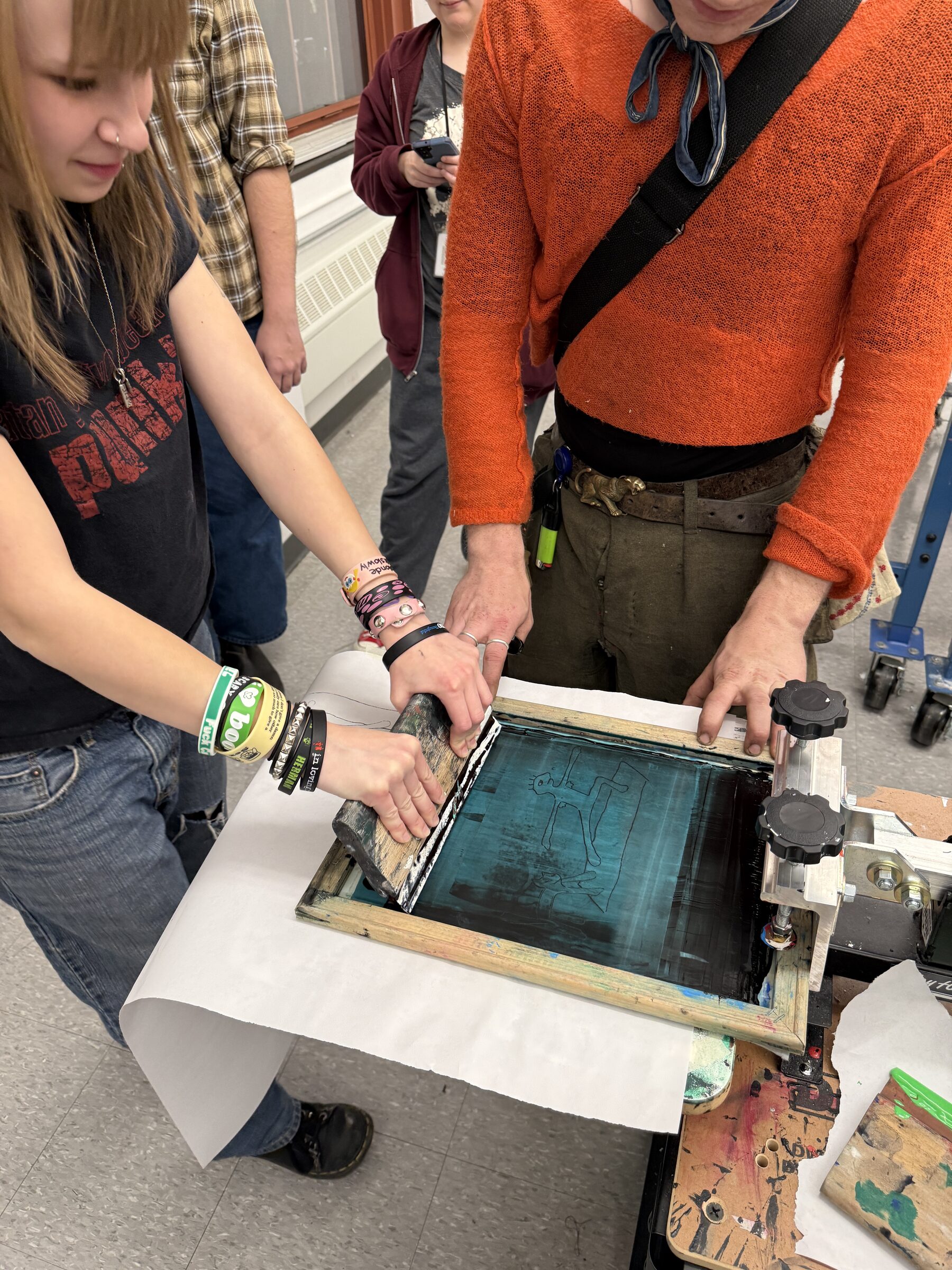 Student pulling ink through a screen