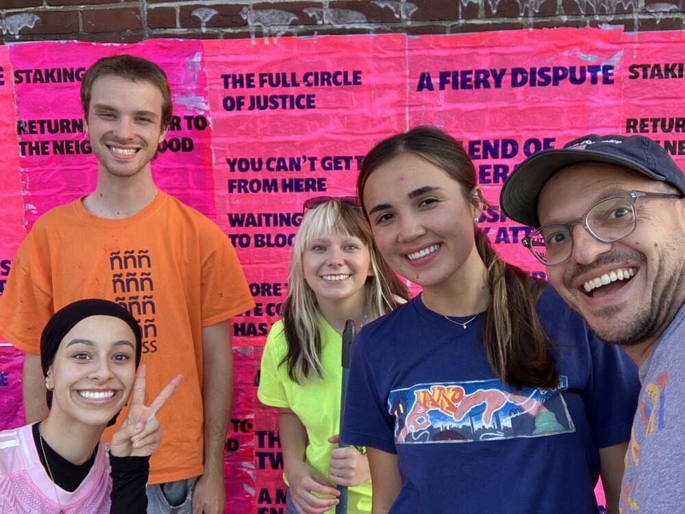 ñ press collaborators in front of the completed wheatpaste installation